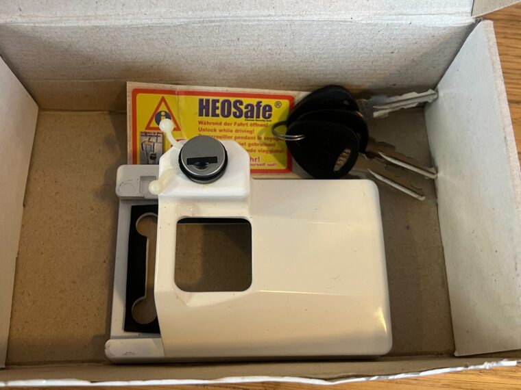 Sécurité porte cellule HEOSAFE blanche montée sur porte de camping-car